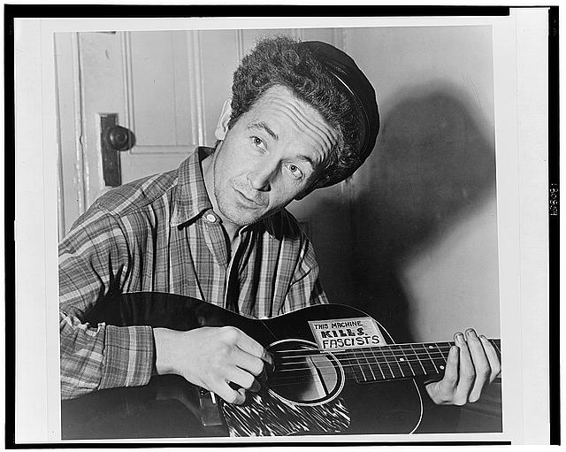 Woody Guthrie playing guitar